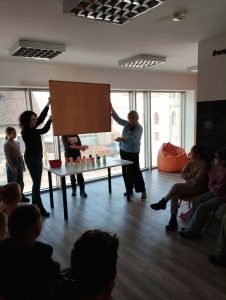 prowadzący zasłaniają dzieciom wzór według, którego muszą ułożyć kulki