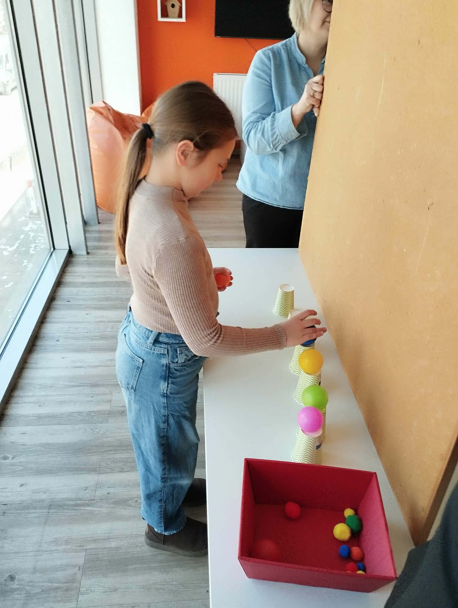 dziewczynka układa kulki w odpowiedni sposób