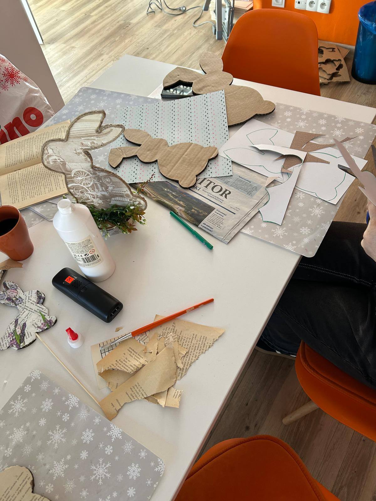 na stole znajdują się materiały potrzebne do zadania, tektura, nożyczki, klej i stare książki