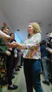 prowadząca rozdaje uczestnikom karteczki z cytatem