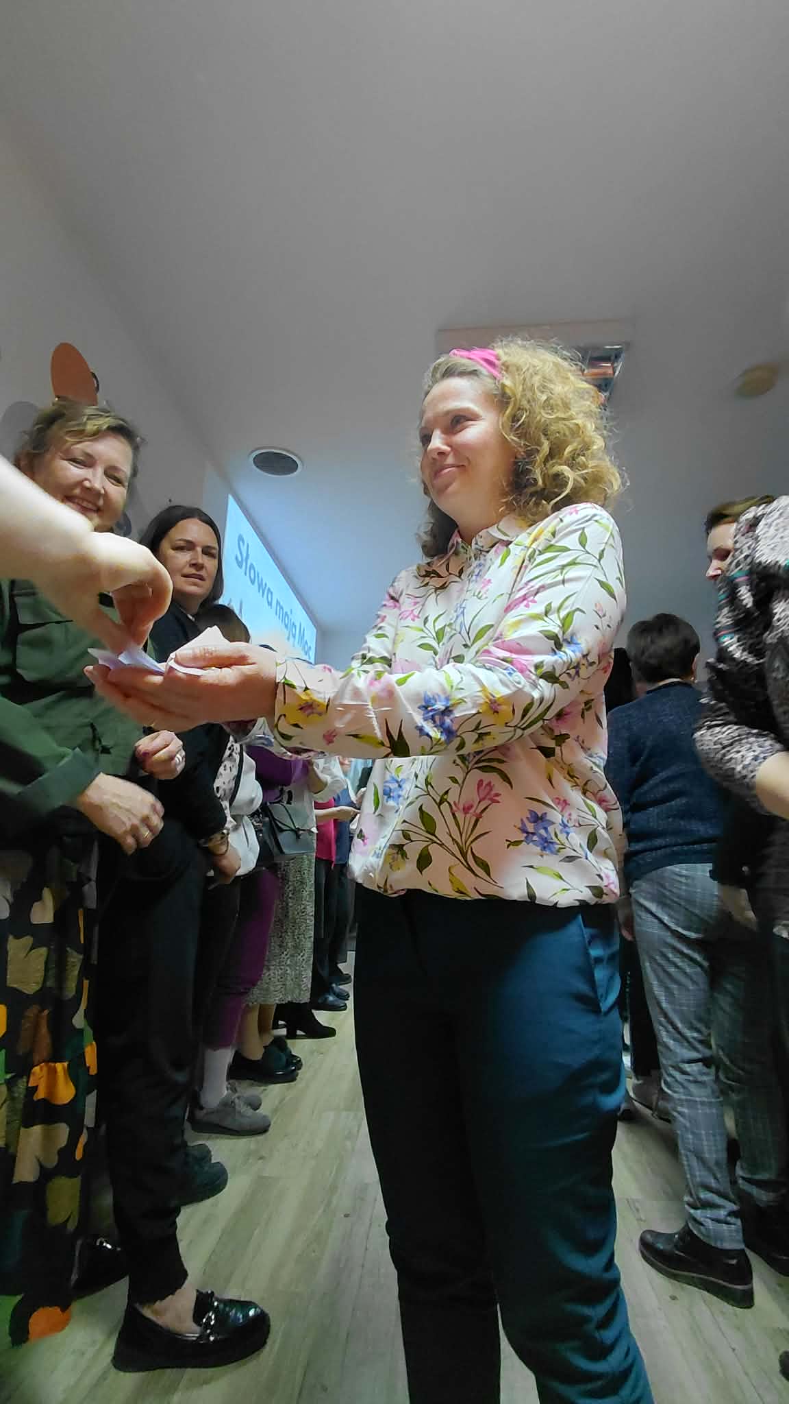 prowadząca rozdaje uczestnikom karteczki z cytatem