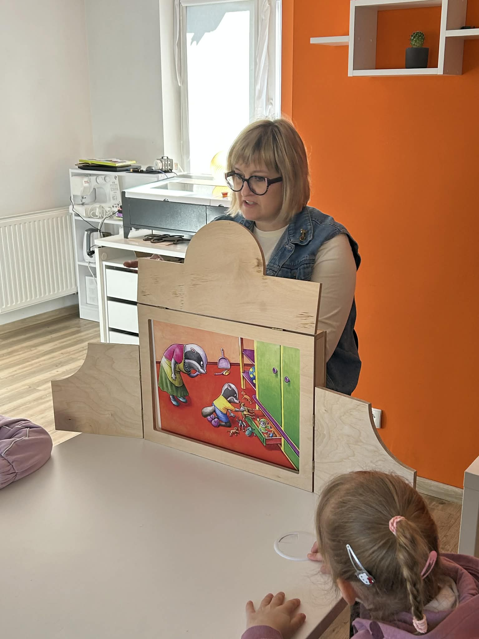 bibliotekarz czyta bajkę w teatrzyku kkamishibai