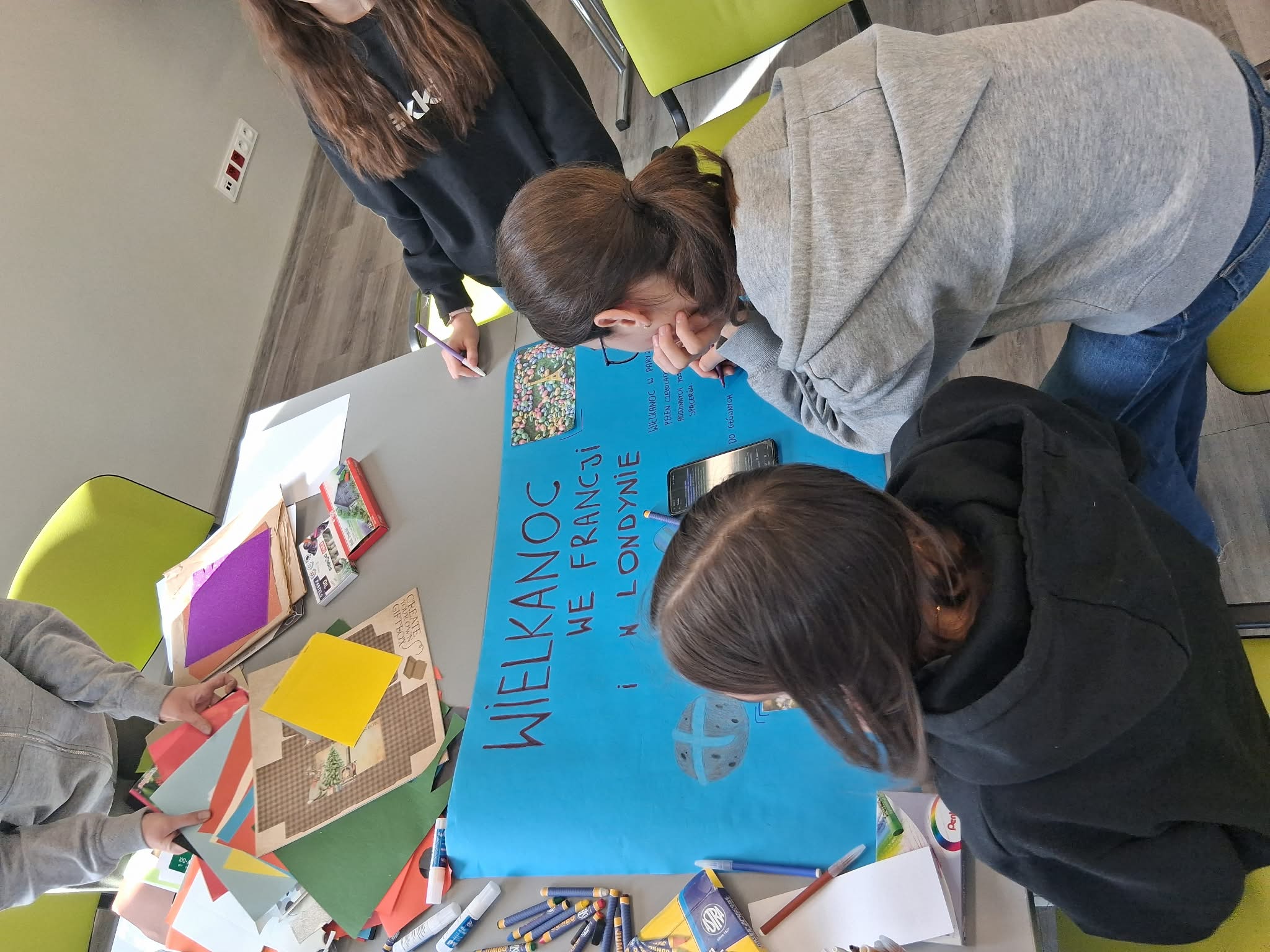 grupa pracuje nad powstaniem plakatu