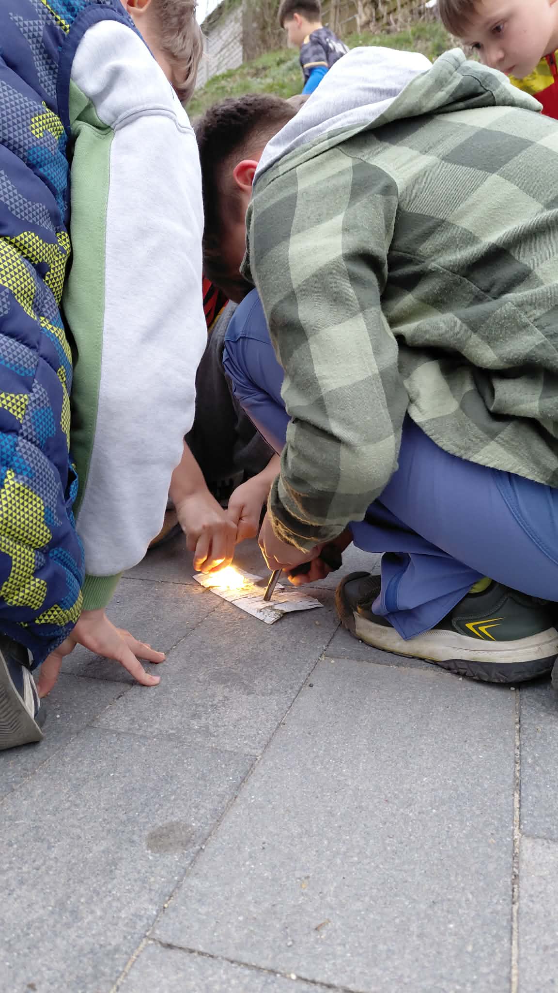 chłopcy próbują rozpalić ogień