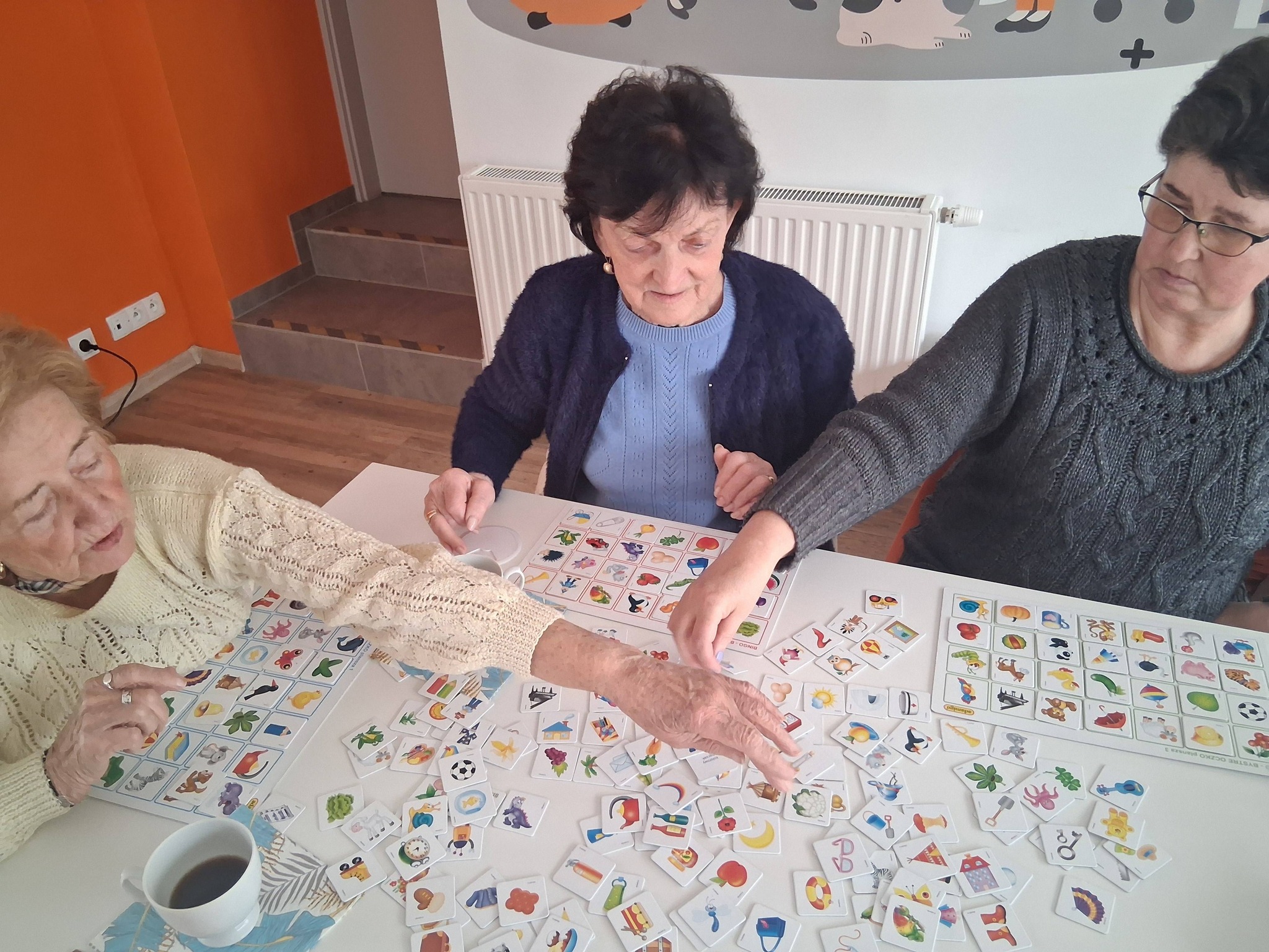 panie odszukują ilustracje, które mają na karcie z gry bystre oczko