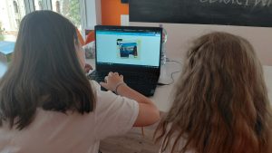 dziewczynki tworzą kartkę na laptopie
