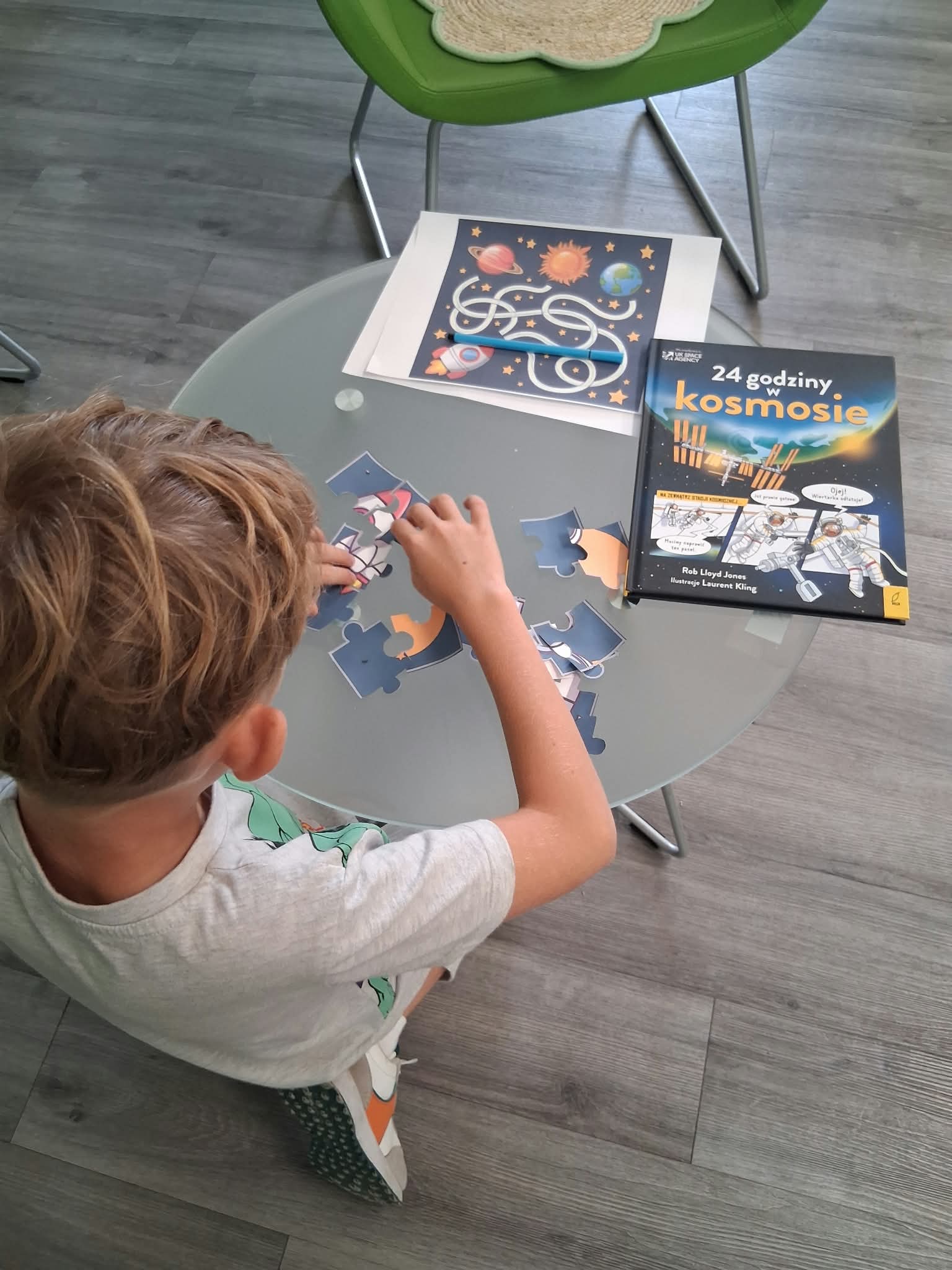 chłopiec układa kosmiczne puzzle