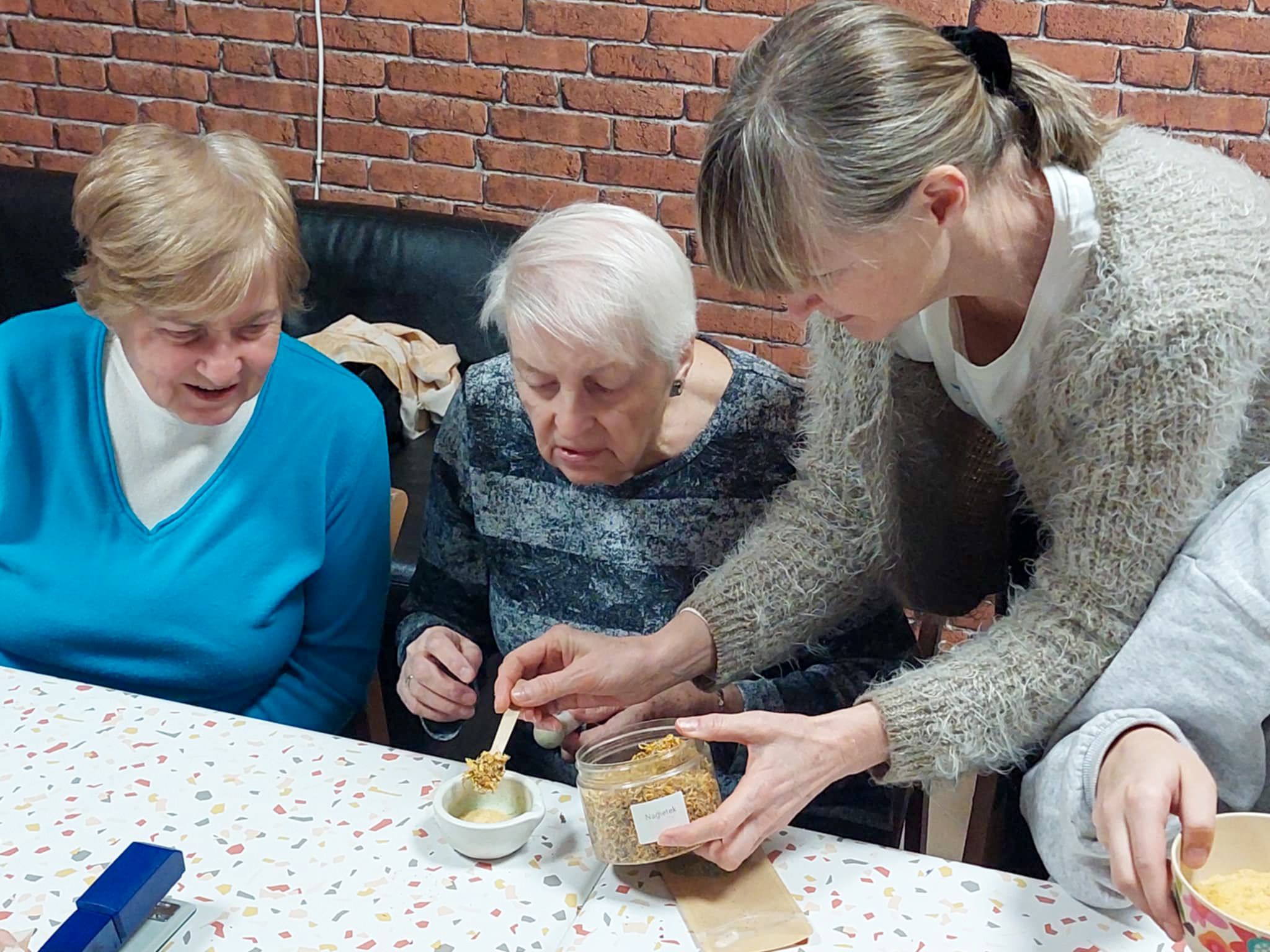 Pani pomaga seniorce w przygotowaniu soli kąpielowych