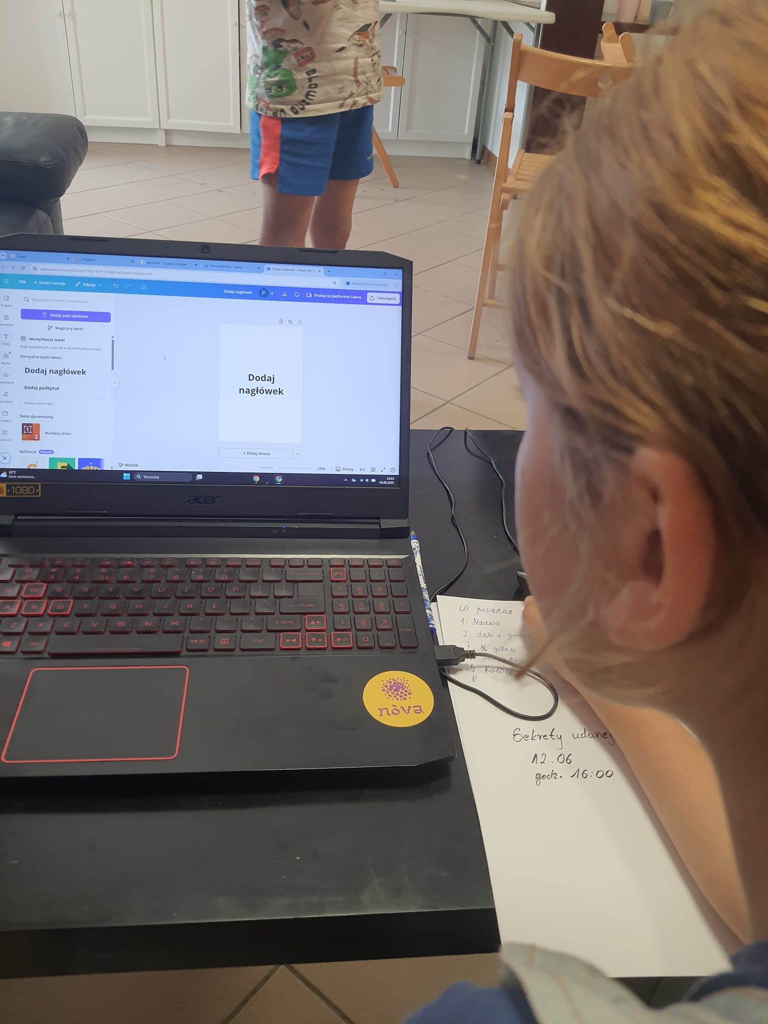 widać kawałek ucha i włosów prawdopodobnie dziewczynki oraz ekran laptopa z napisem 