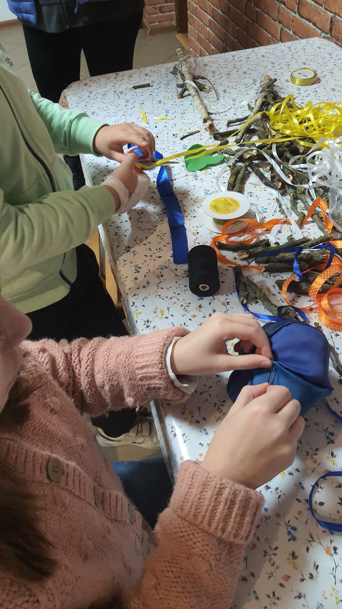 dziecięce ręce zszywają ręcznie otwór w dyni