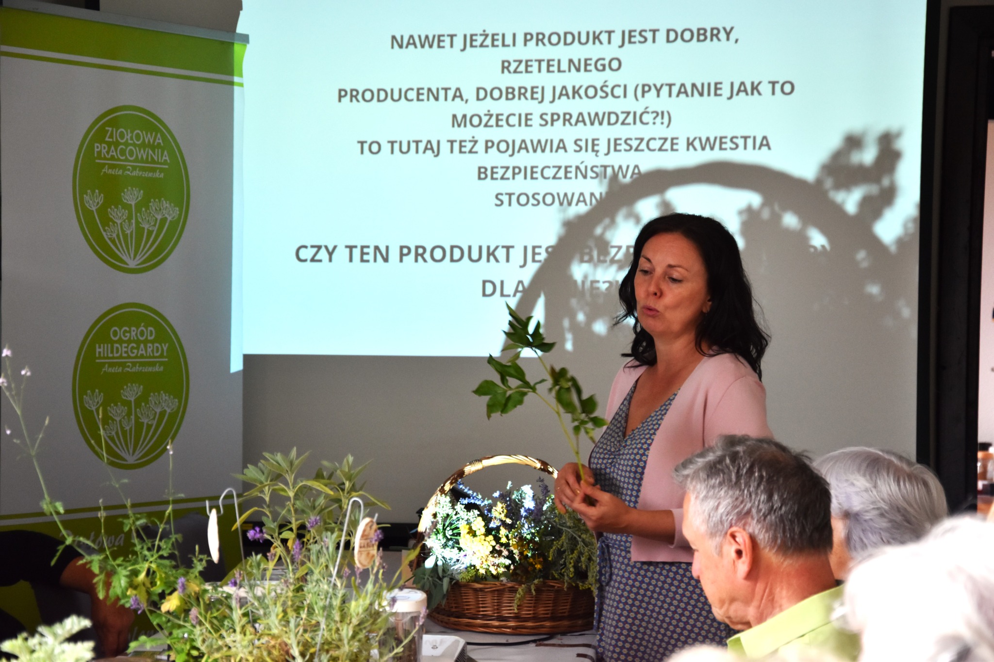 Prowadząca z roślinami przy projektorze