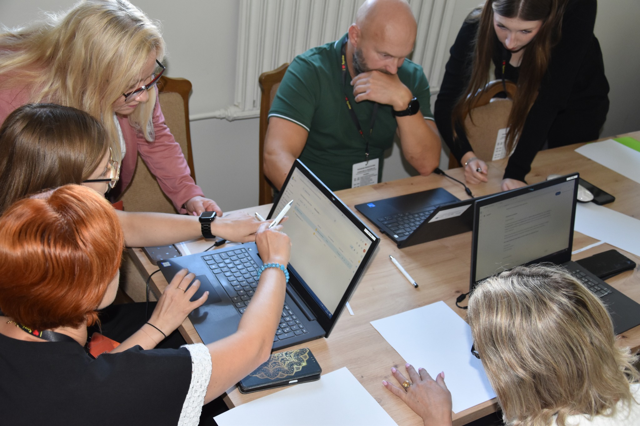 grupa osób siedząca przy laptopach