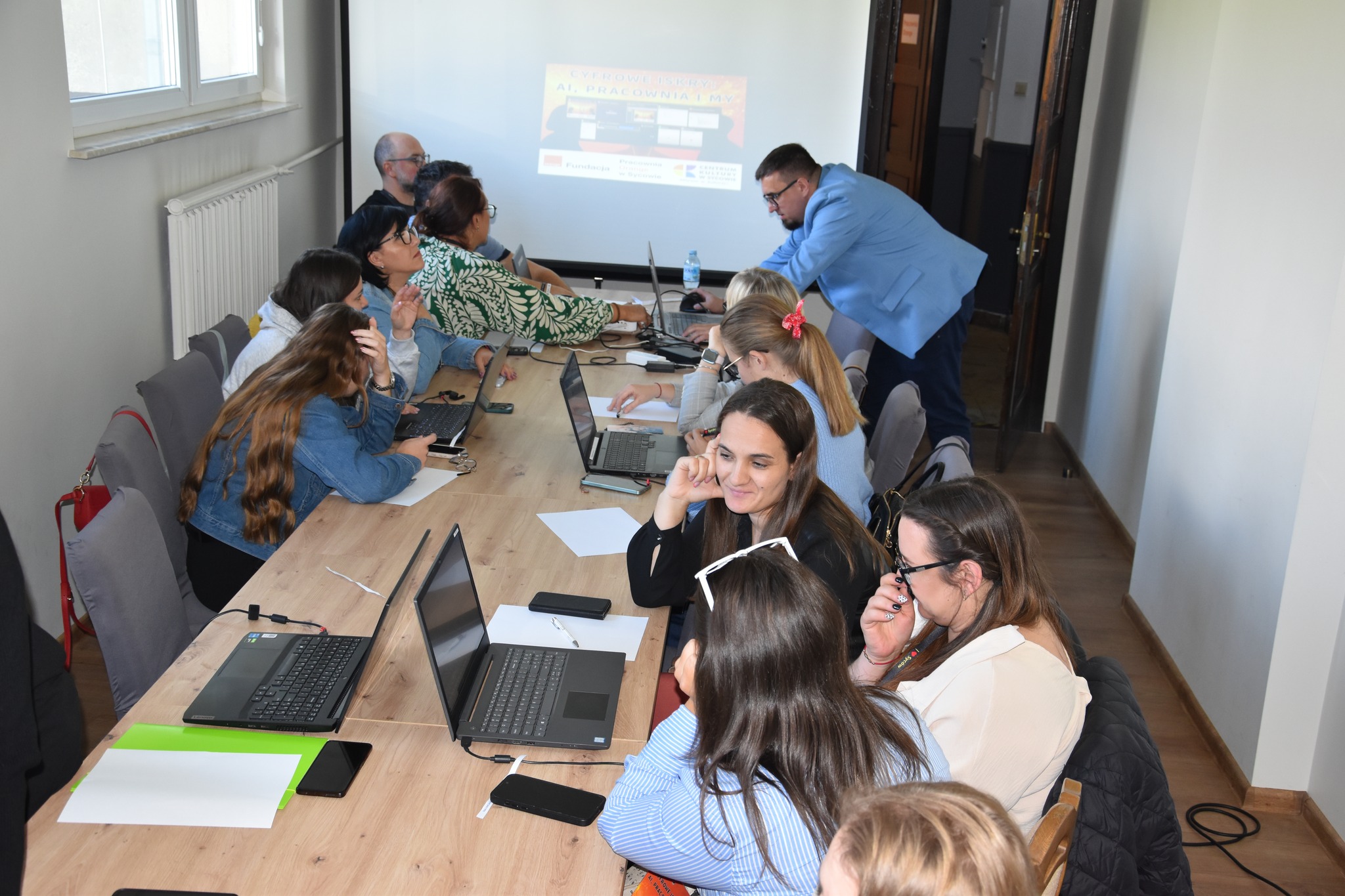 Grupa warszatowa przy biurku z laptopami