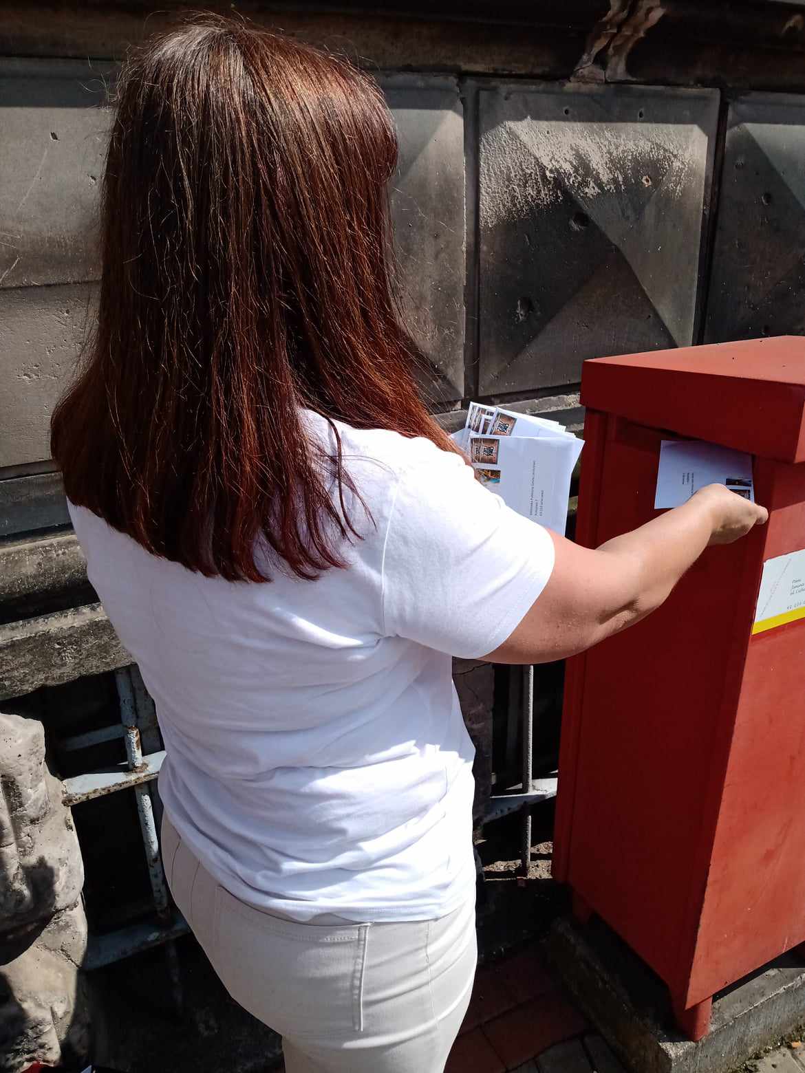 Zdjęcie przedstawiające liderkę Pracowni Orange wkładającą koperty do skrzynki pocztowej