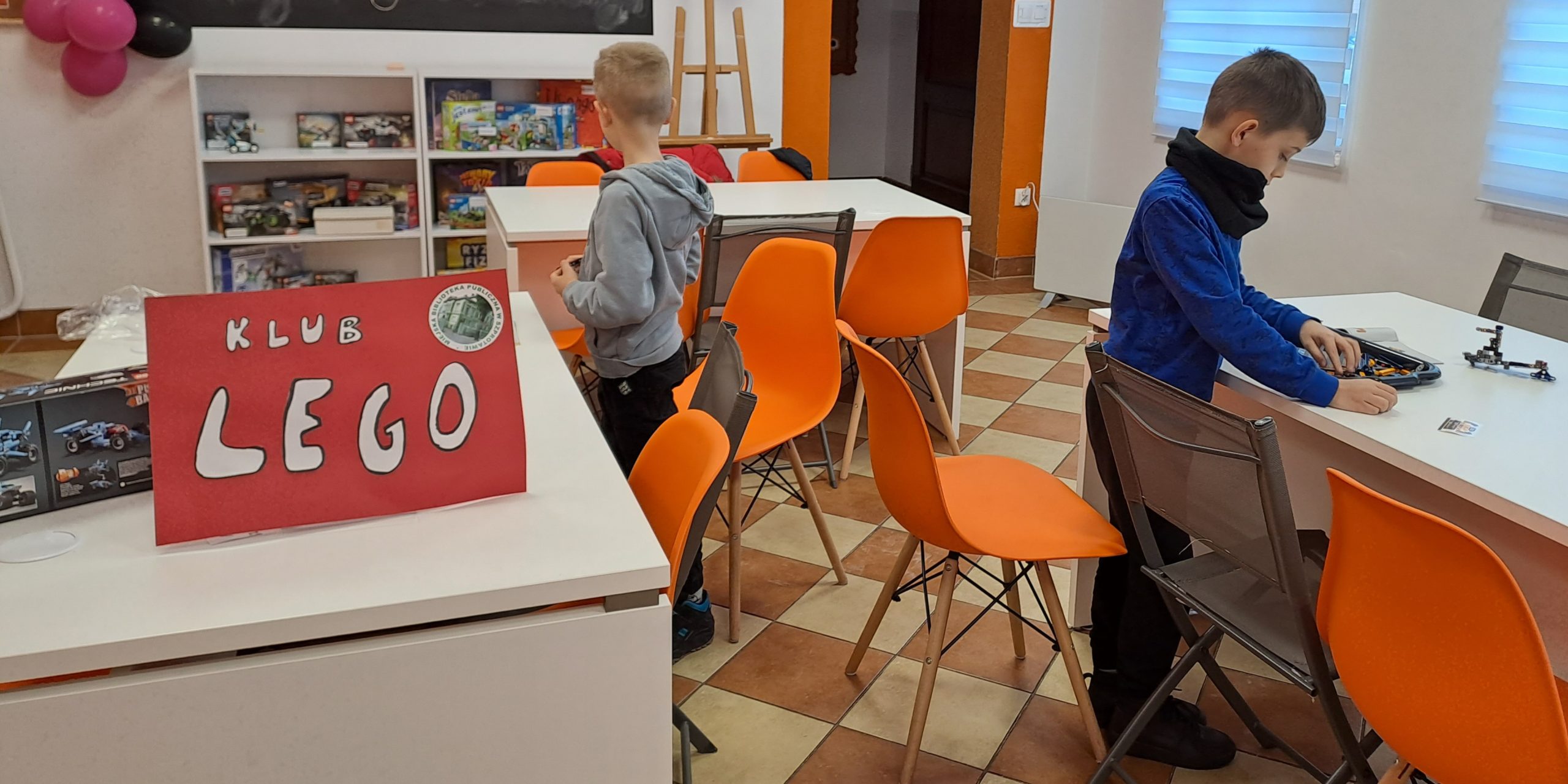 zdjęcie dzieci przy stolikach podczas układania modeli lego