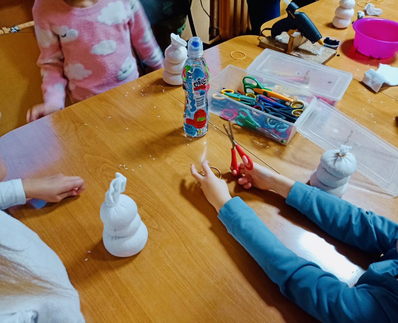 zdjęcie dzieci przygotowujących materiały do dekoracji bałwanków