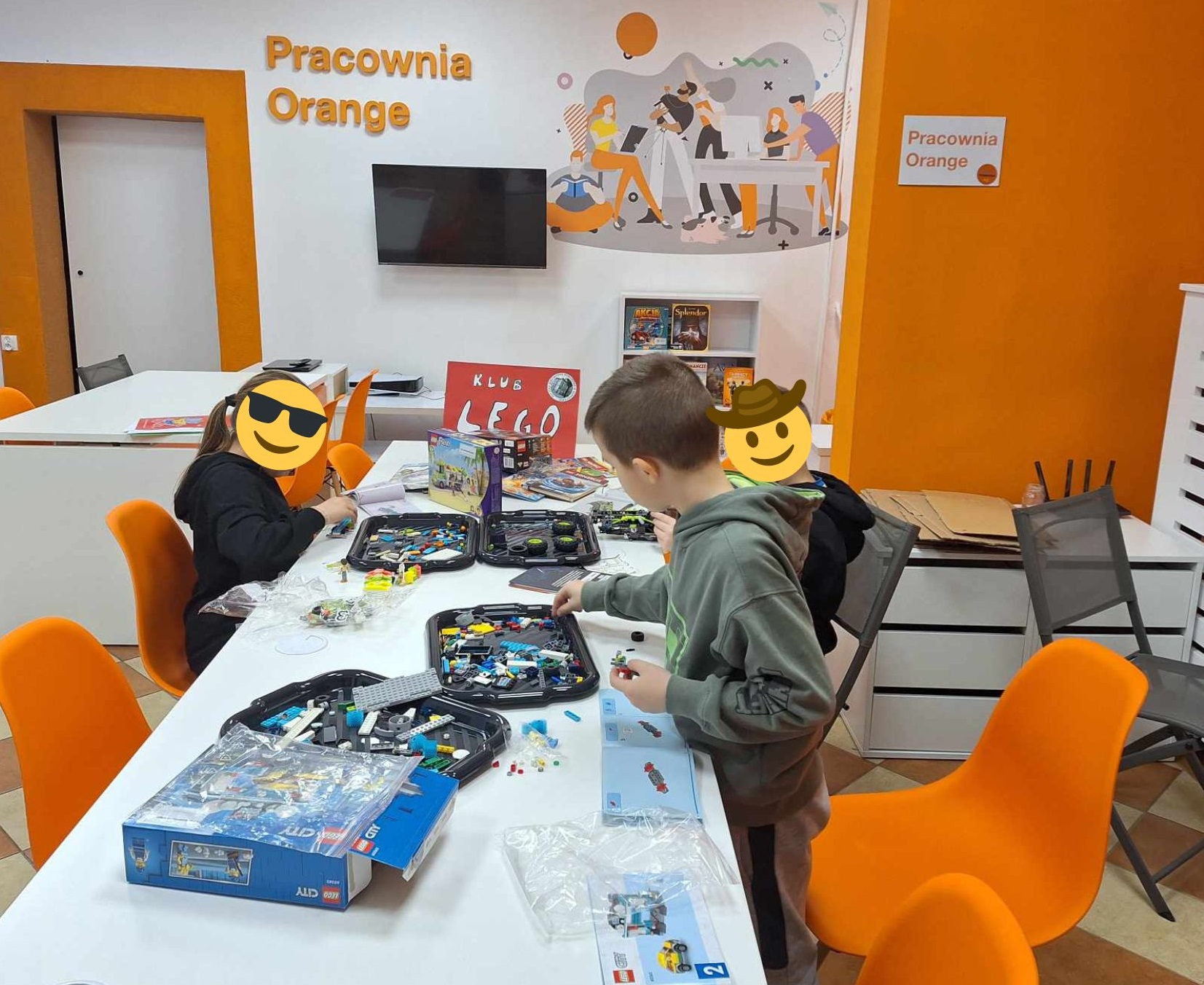 zdjęcie dzieci przy stoliku podczas układania modeli z klocków lego w pracowni orange