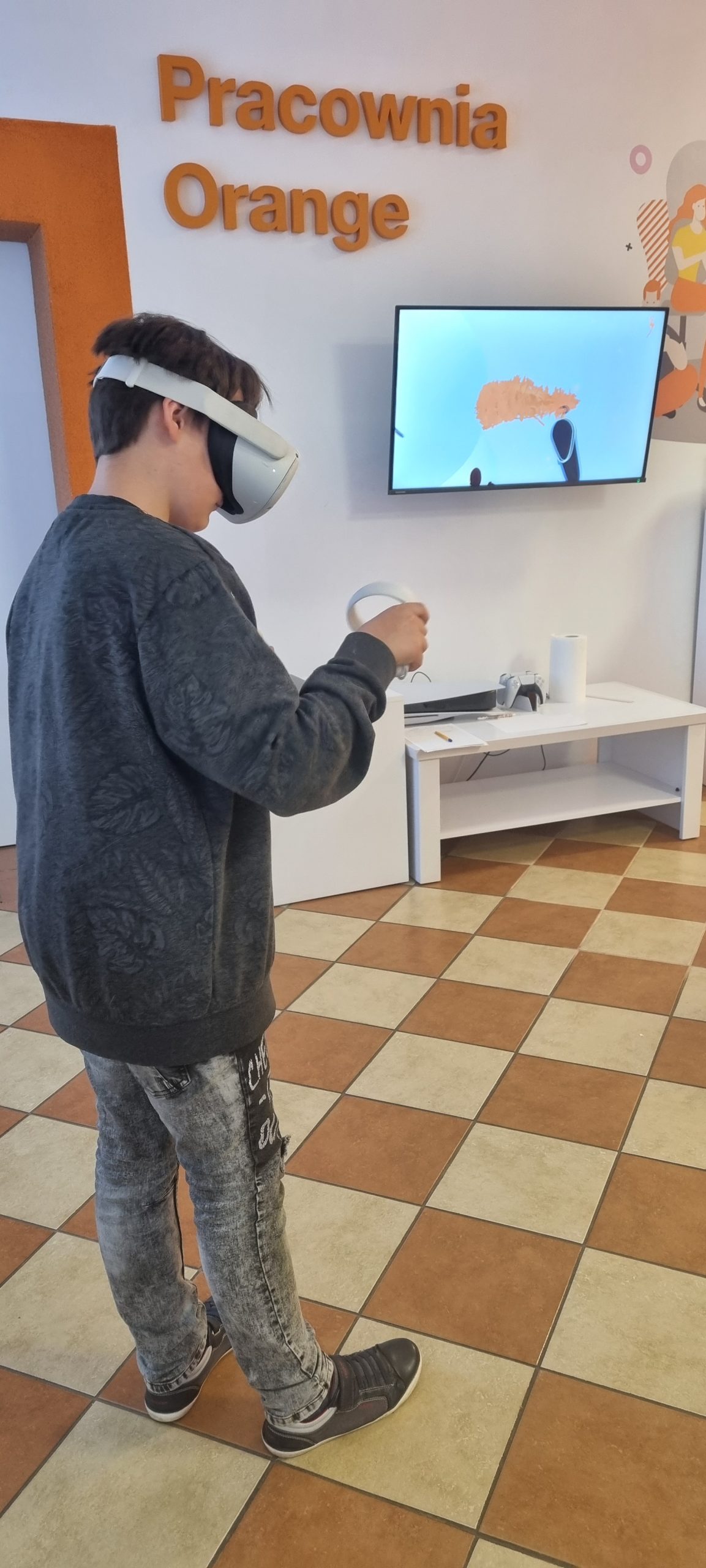 zdjęcie chłopca w goglach VR podczas malowania elementów bałwanka w aplikacji open brush