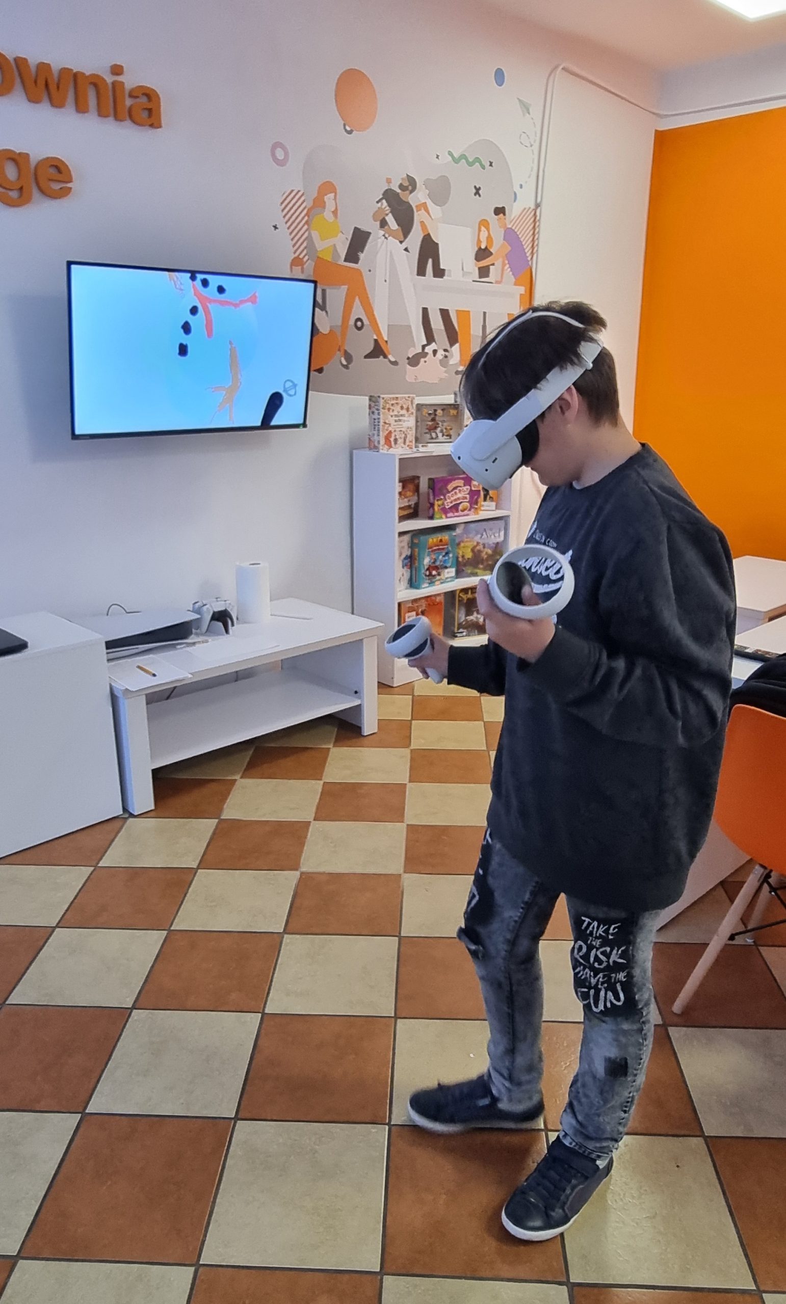 zdjęcie chłopca w założonych goglach VR podczas malowania atrybutów bałwana w aplikacji open brush