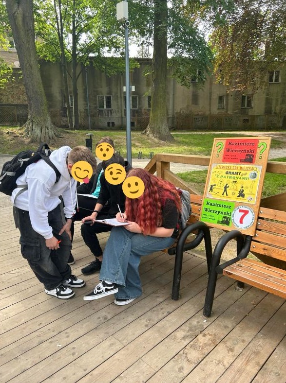 zdjęcie młodzieży rozwiązującej zadanie przy tablicy w parku