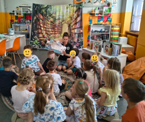 zdjęcie bibliotekarki pokazującej dzieciom książkę o radości