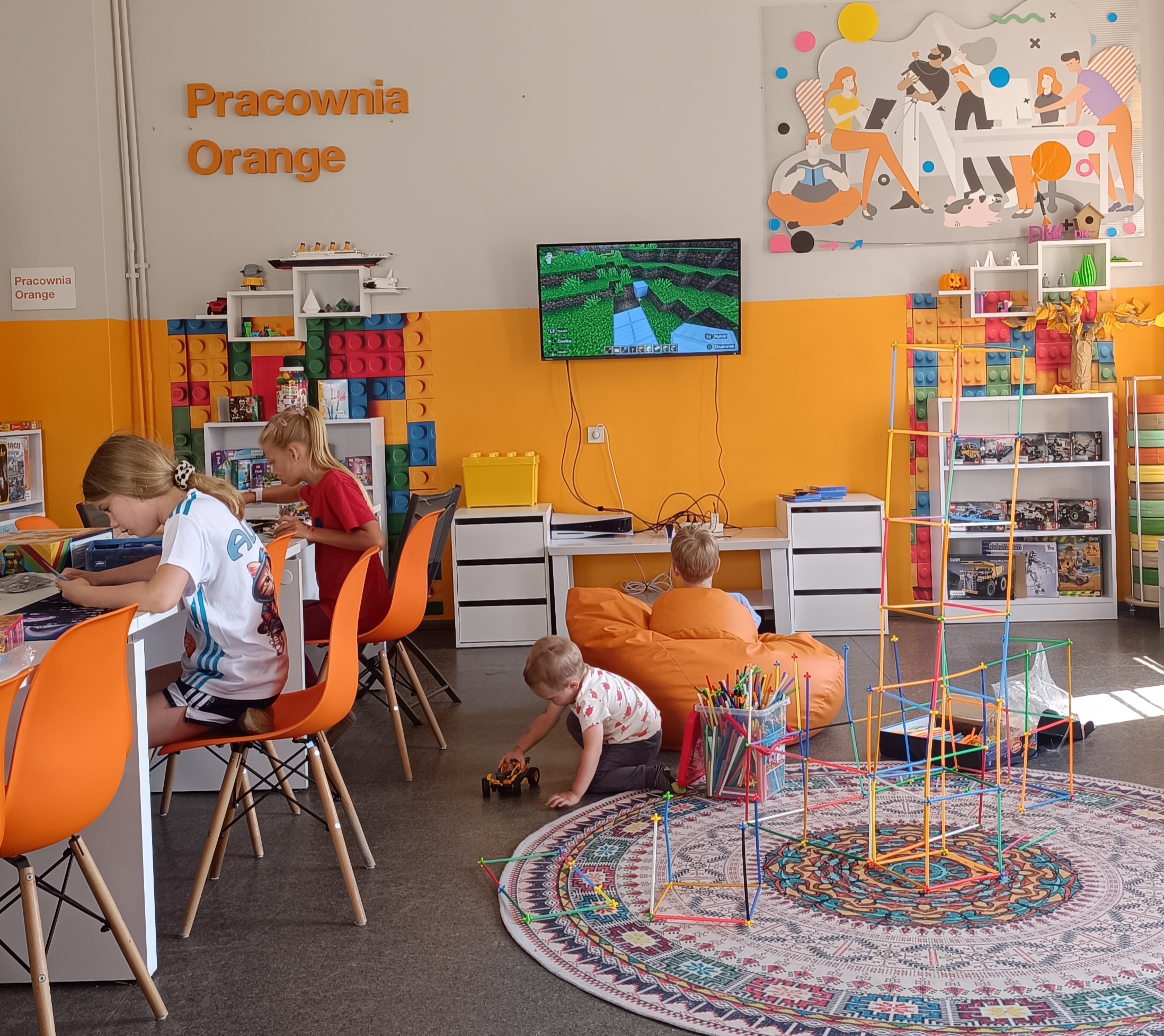 Zdjęcie dzieci w Pracowni Orange, każde z nich zajęte jest zabawą, grą na konsol,