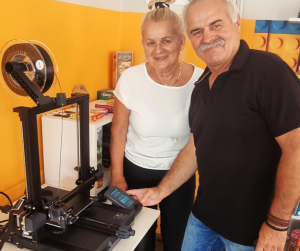 zdjęcie uśmiechniętych seniorów przy drukarce 3D