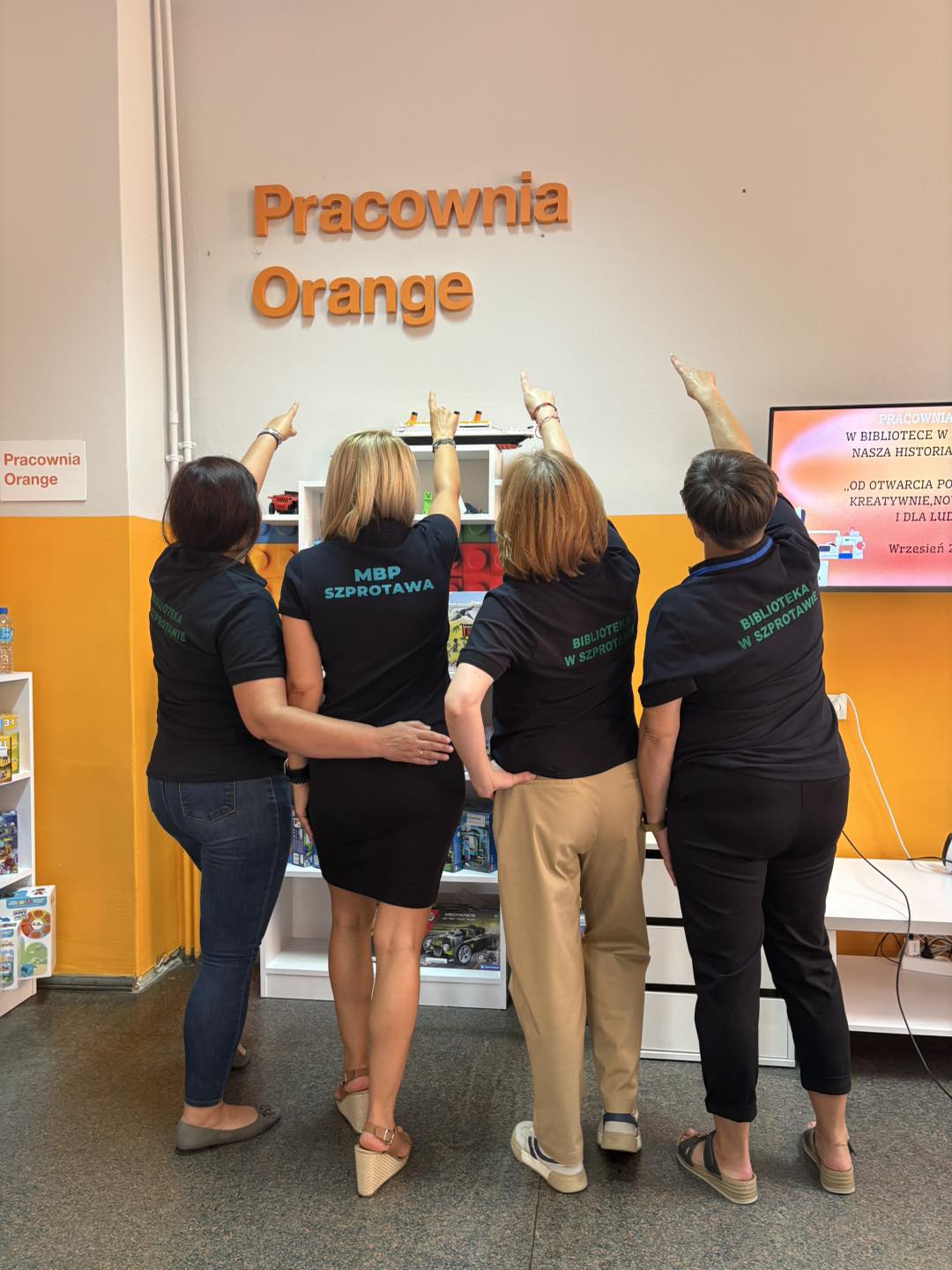 zdjęcie liderek pracowni w szprotawie wskazującej na napis pracownia orange na ścianie