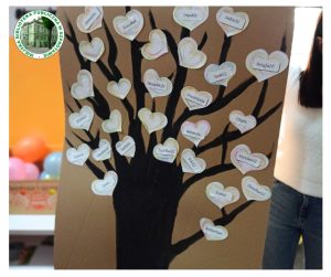 zdjęcie przedstawia czarne drzewo na szarym kartonie z sercami narysowanymi kolorowowymi kredkami i przyklejonymi do nich kartkami z hasłami nawiązującymi do hasła tolerancja
