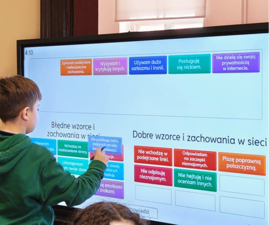 zdjęcie chłopca rozwiązującego zadanie na tablicy dotykowej