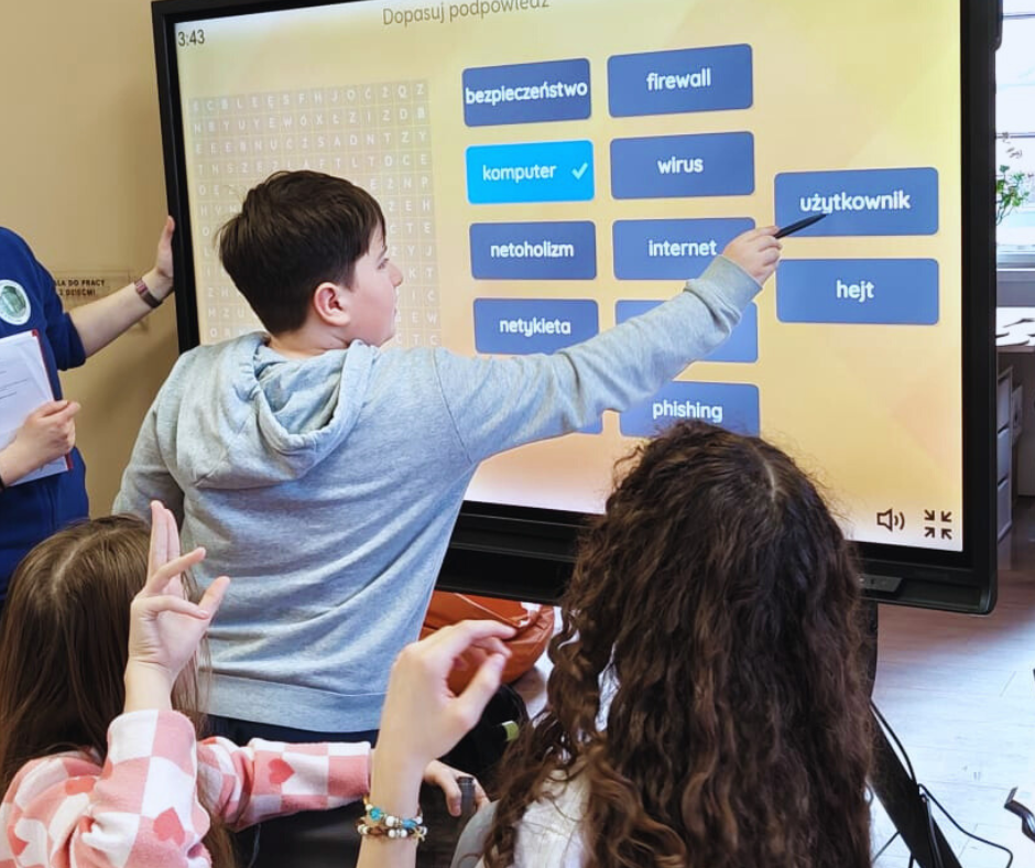 zdjęcie chłopca zaznaczającego odpowiedź na ekranie dotykowym