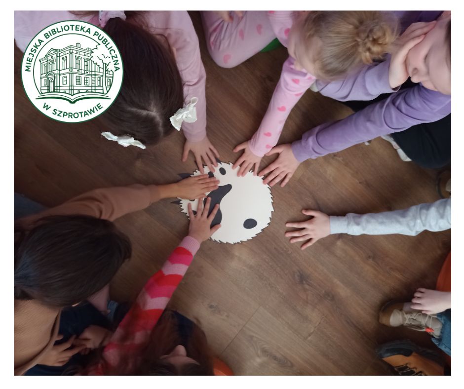 dłonie dzieci na papierowej łapie niedźwiedzia polarnego w rzeczywistym rozmiarze, widok z góry