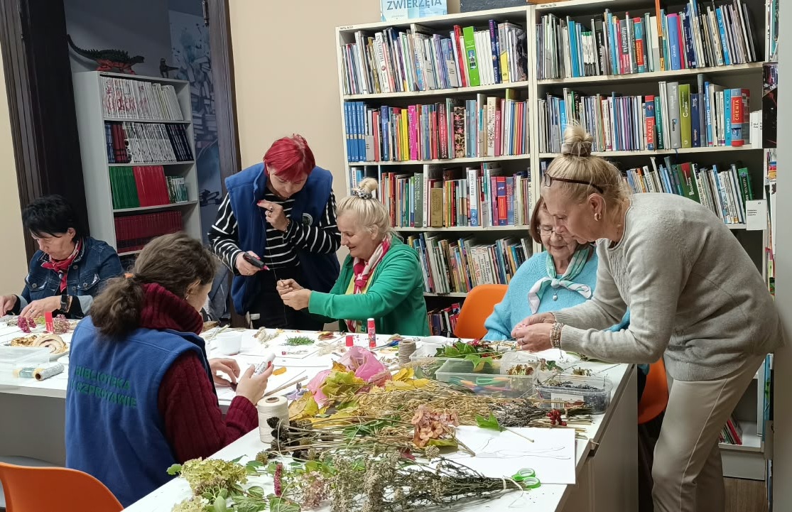 zdjęcie bibliotekarek i kobiet podczas klejenia liści i traw na kartki