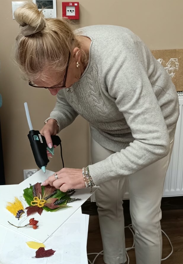 zdjęcie kobiety naklejającej liście na podkładkę