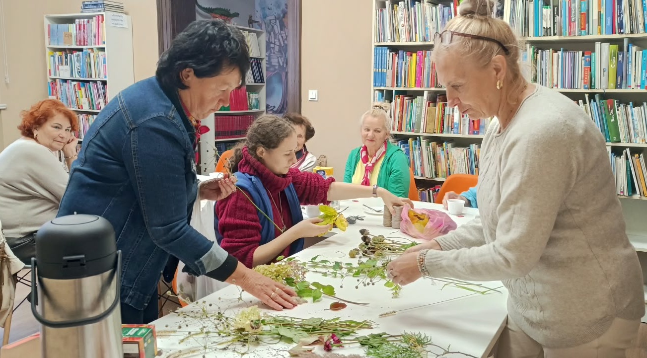 zdjęcie bibliotekarki i czytelniczek podczas wybierania liści i zbóż do pracy plastycznej