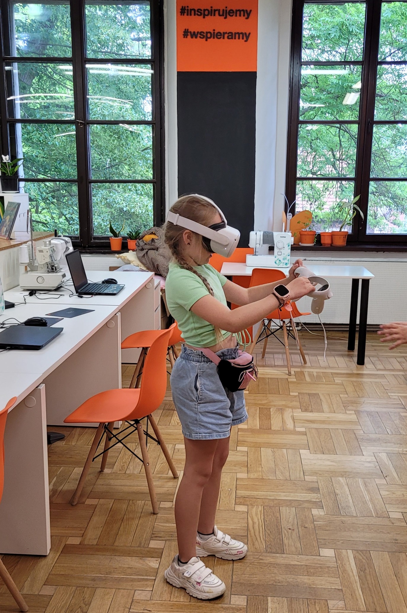 Na zdjęciu widać dziewczynkę która stoi, ma założone gogle vr.