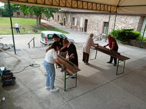 Grupa osób czyszczących ławki.
