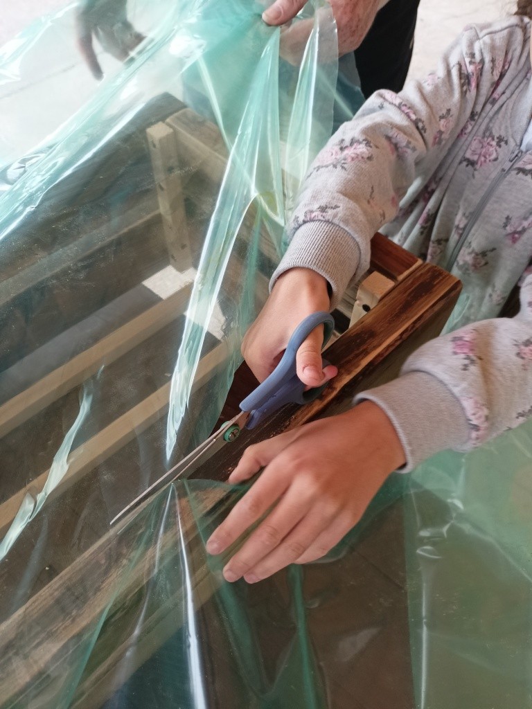 zdjęcie dziecka tnącego folię nożyczkami