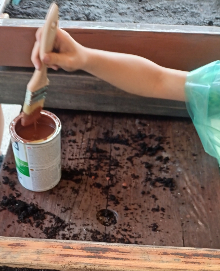 ręka dziecka z pędzlem zanurzanym w farbie