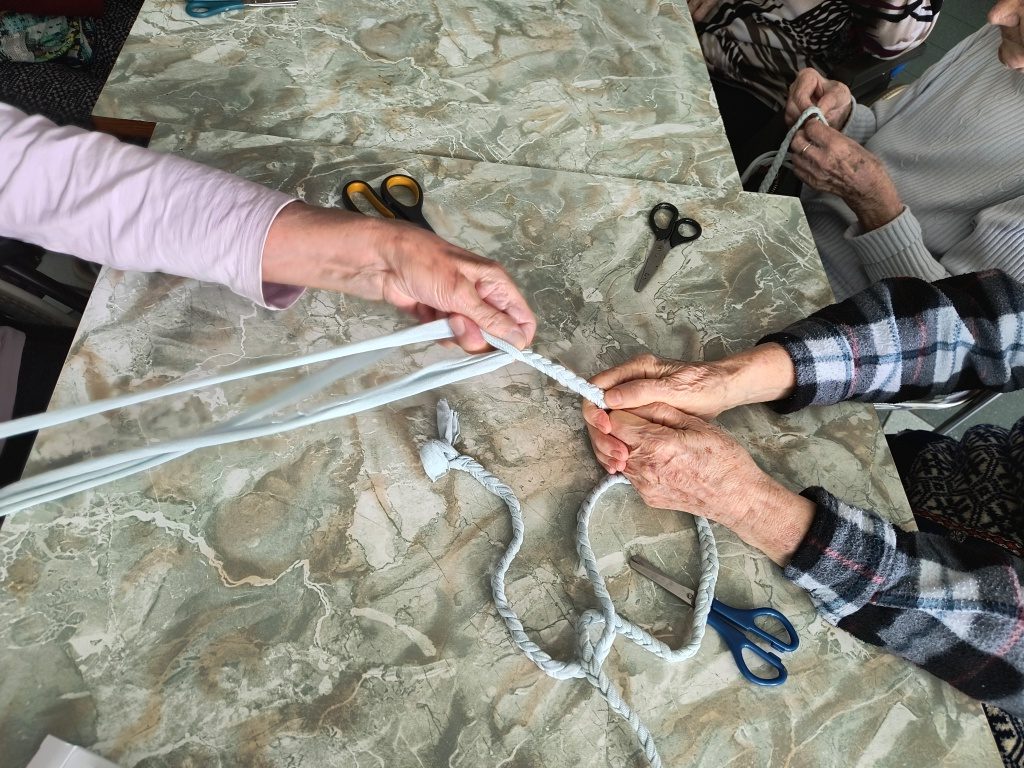 na zdjęciu widać ręce kobiet trzymające sznurek