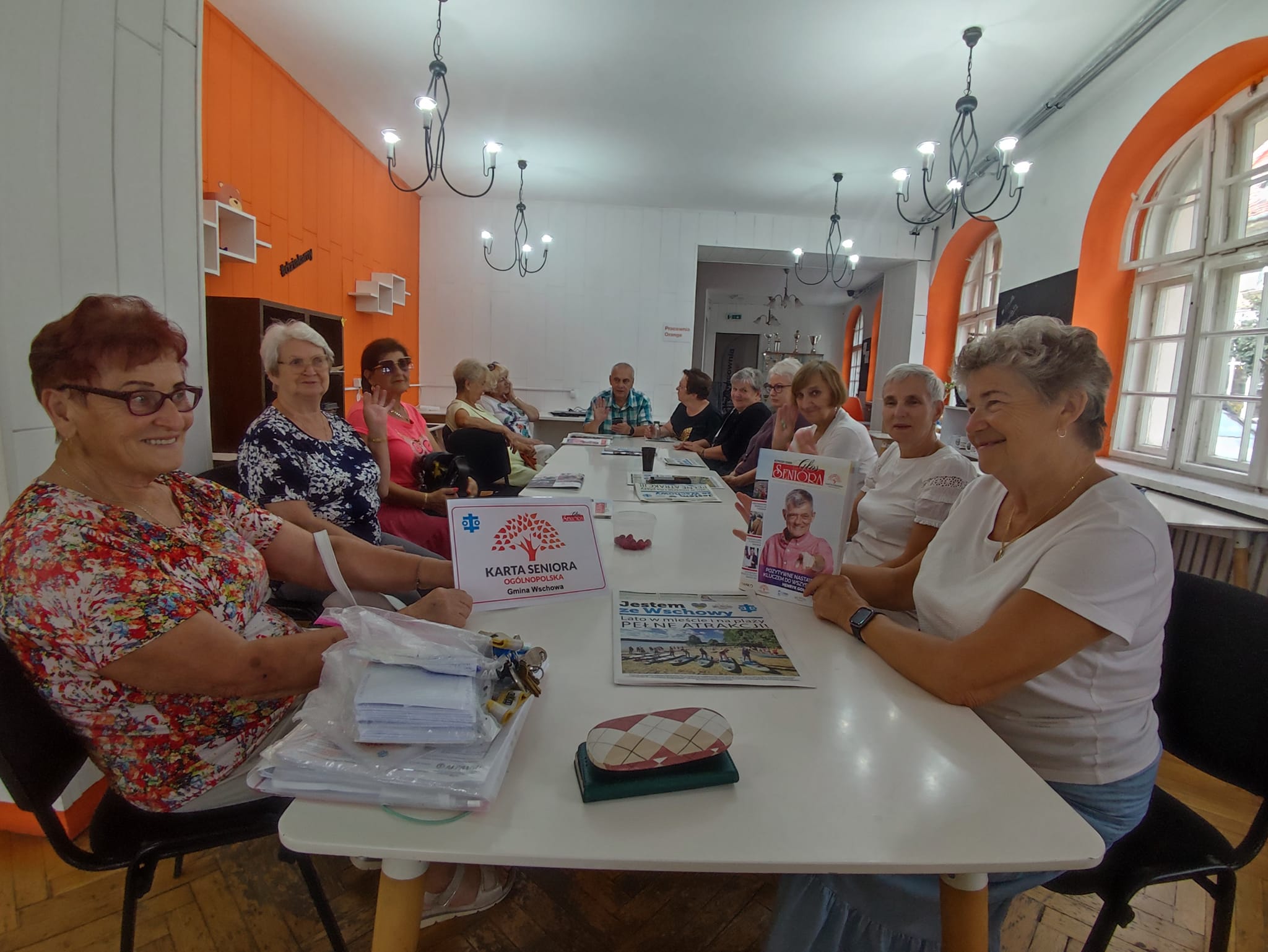 Grupa seniorów i seniorek pozuje do zdjęcia.