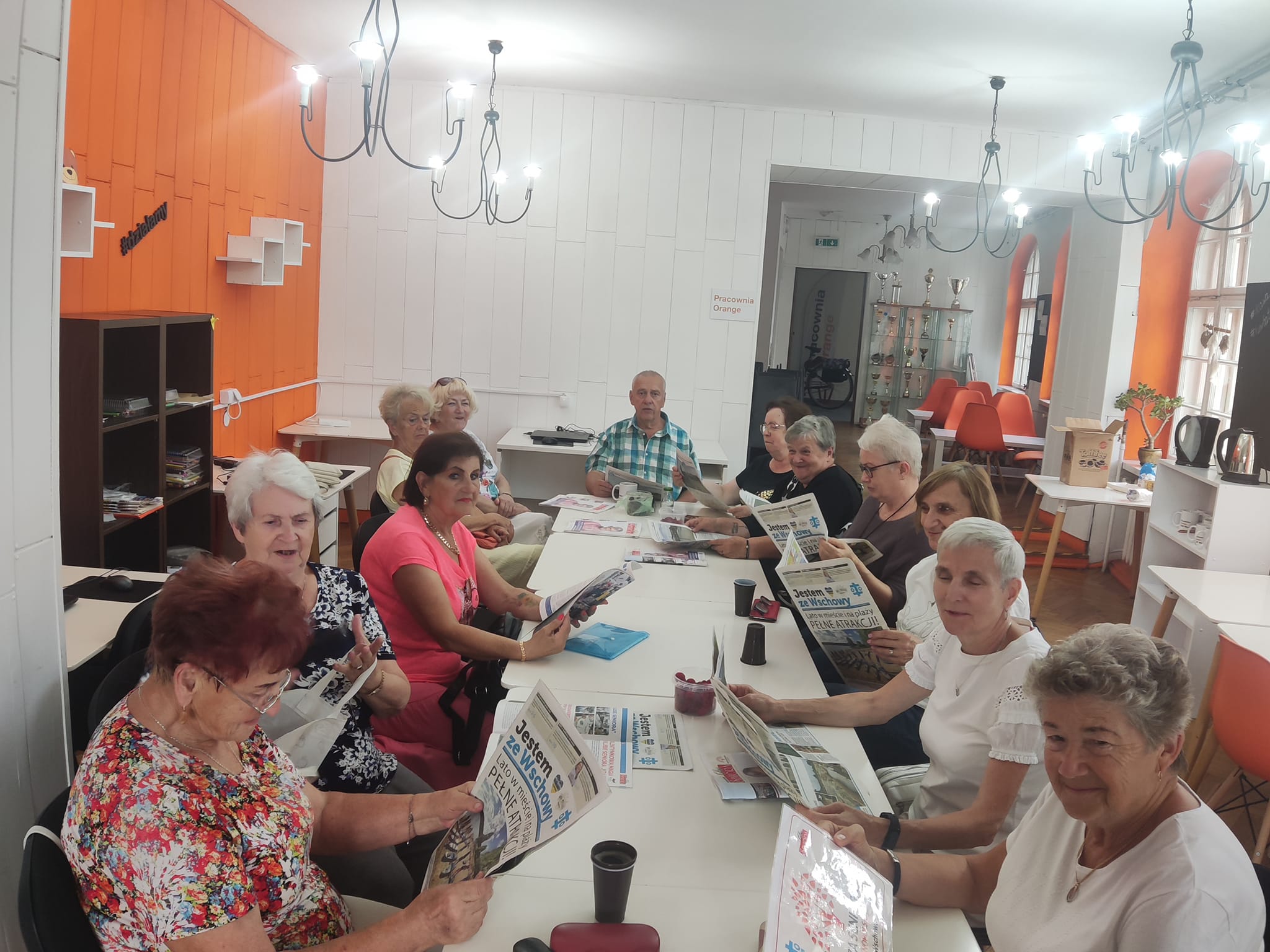 Grupa seniorów i seniorek pozuje do zdjęcia.