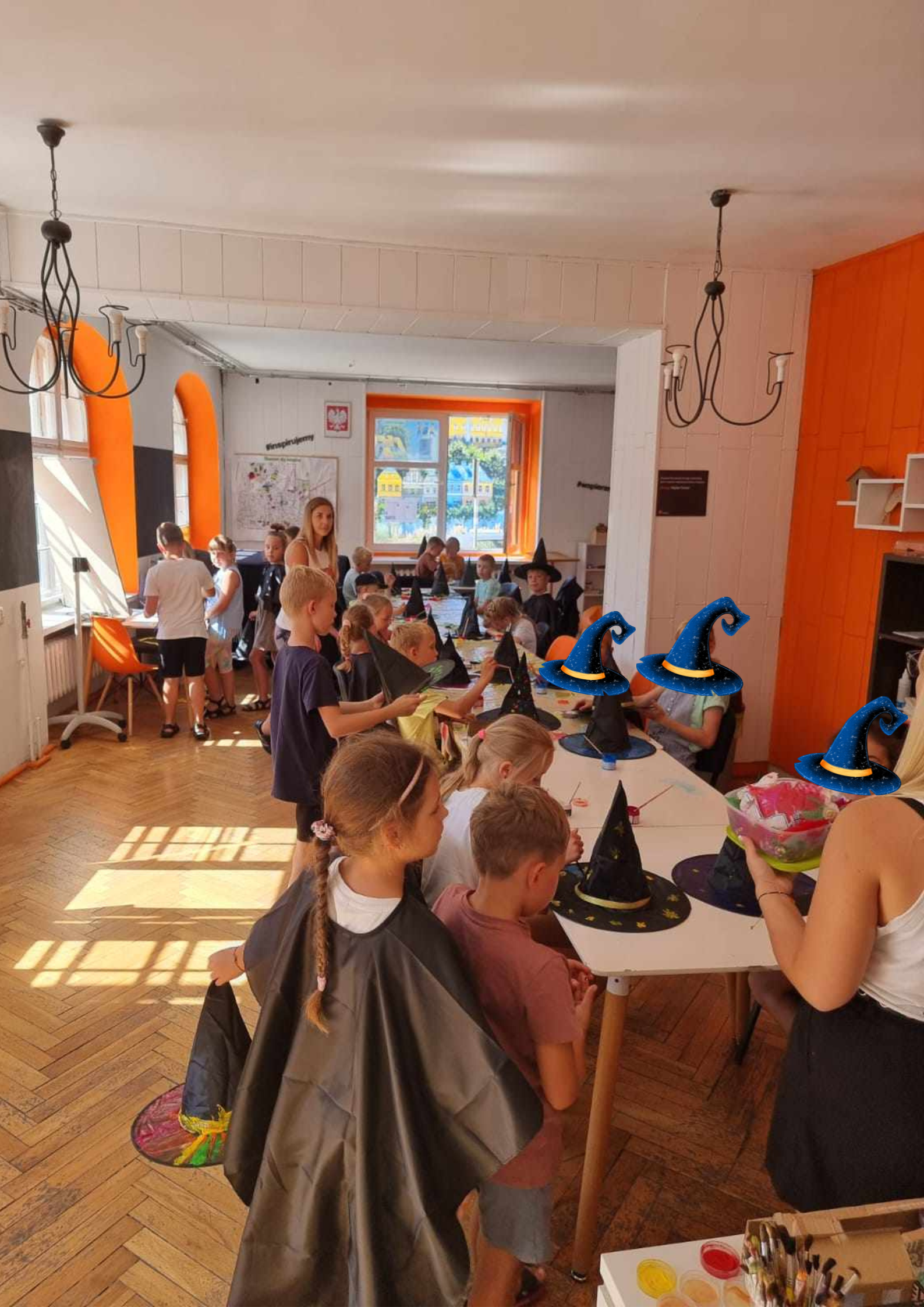 Grupa dzieci przy stołach pracuje na warsztatach.