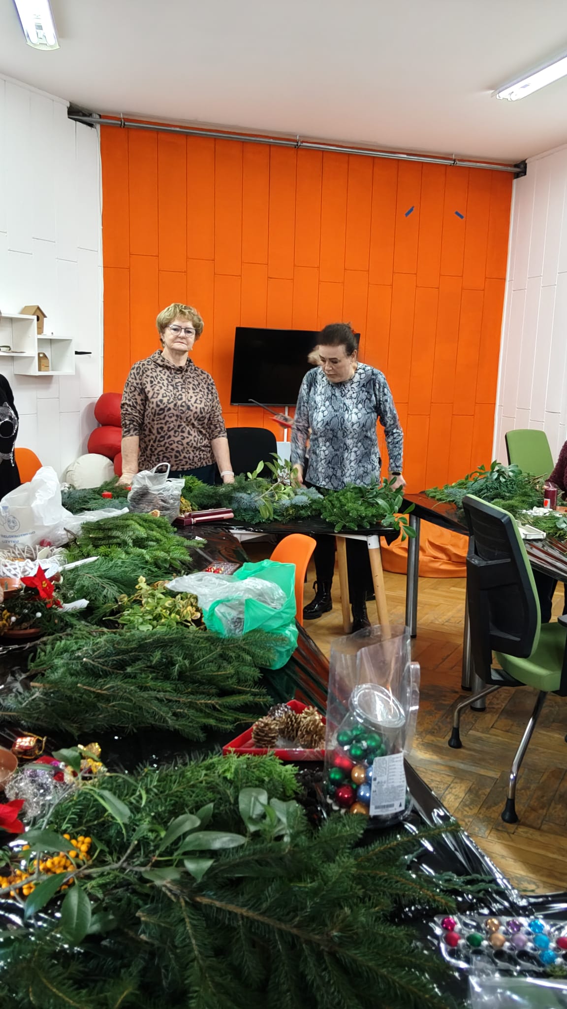 Dwie uczestniczki warsztatów stoją przy stole.