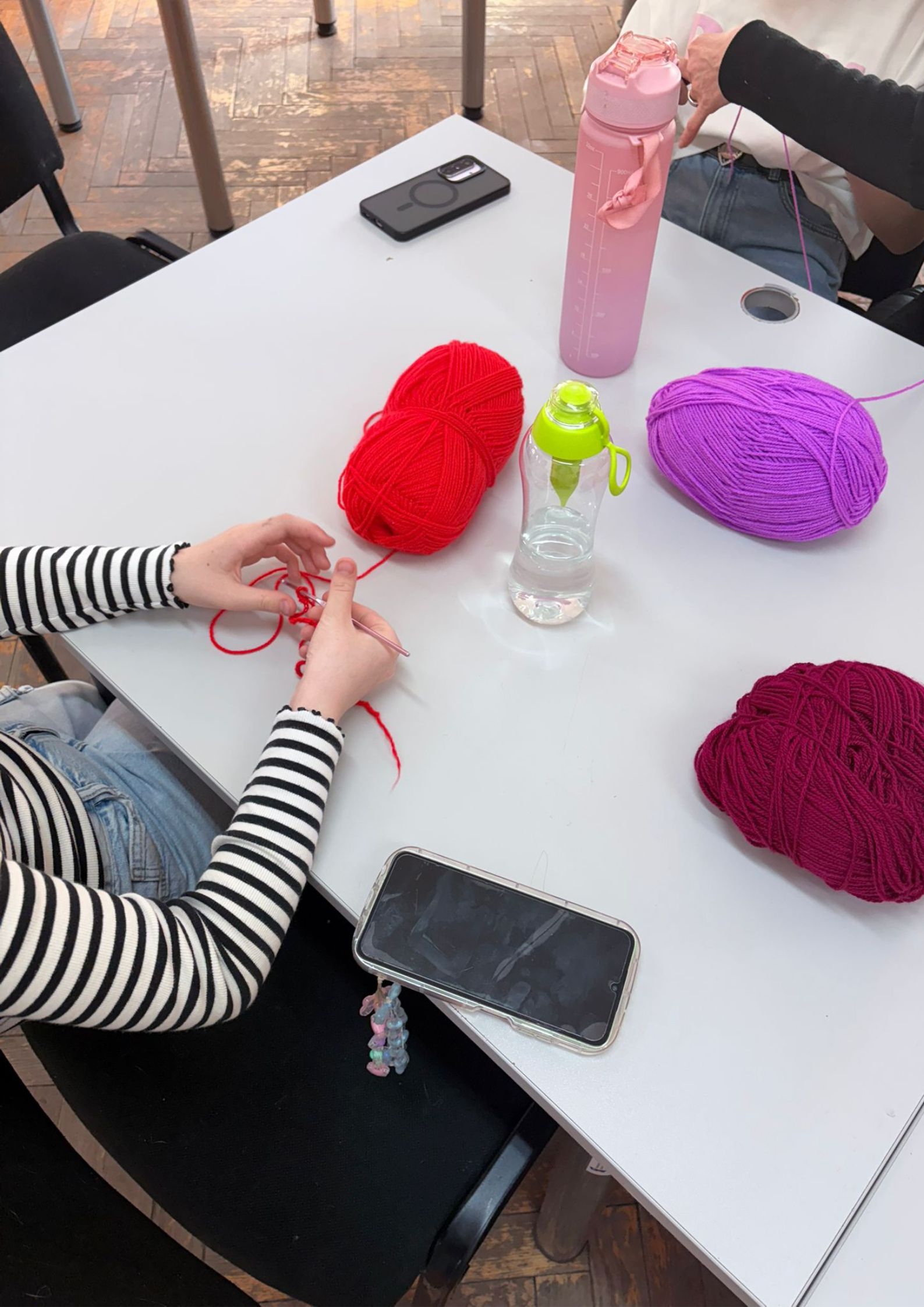 Na zdjęciu osoby tworzą prace z włóczki