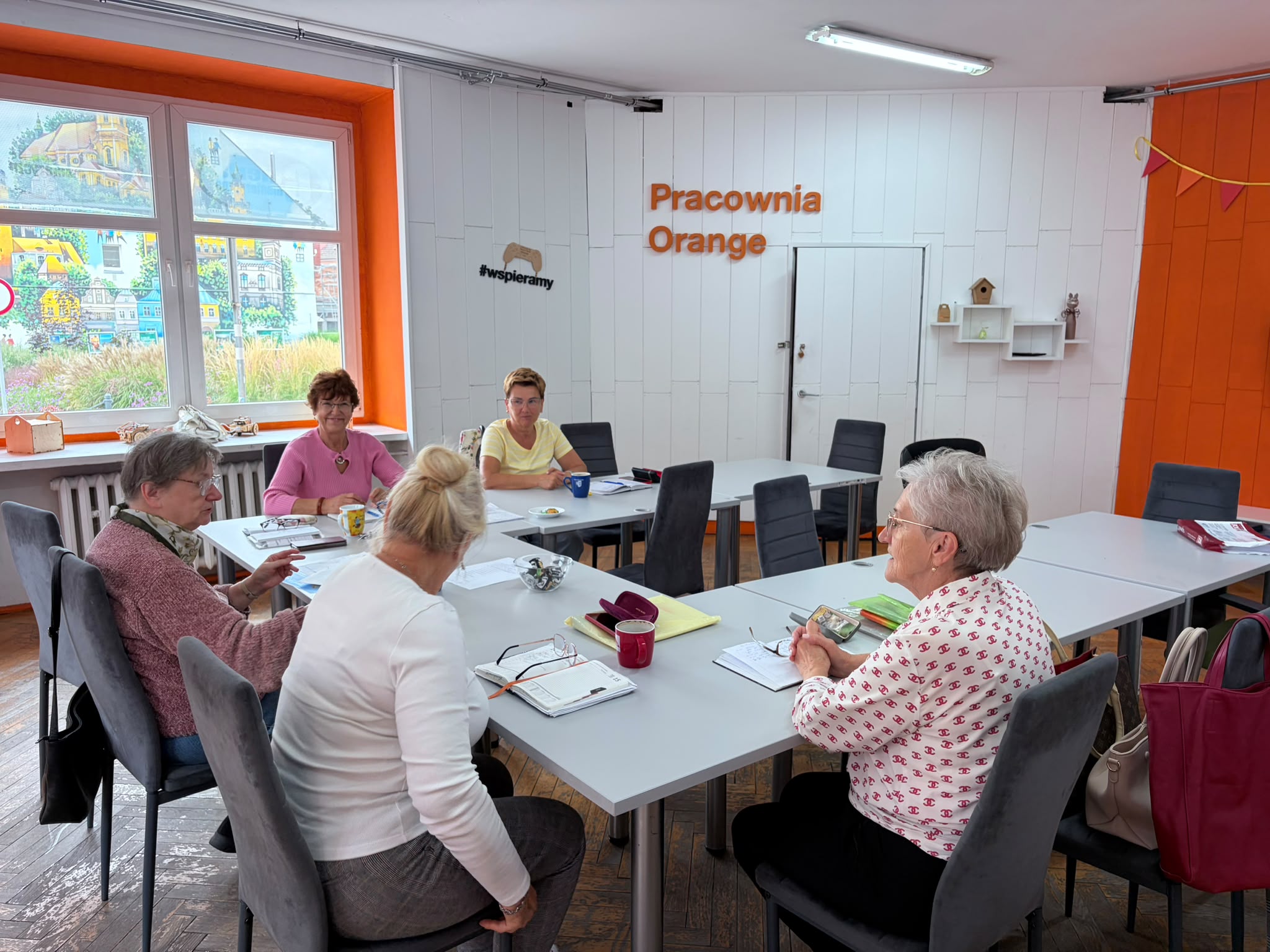 Zarząd UTW - grupa kobiet siedzących przy stole.
