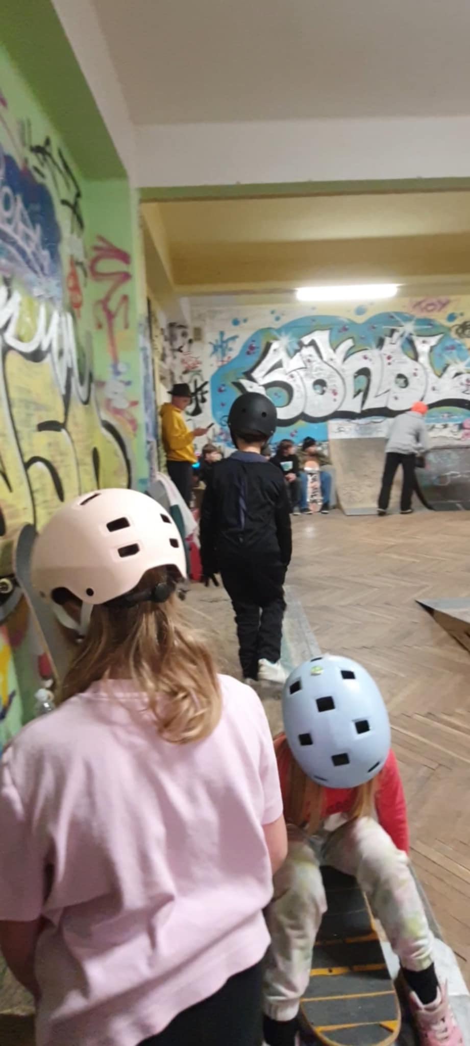 Grupa dzieci bawi się na skateparku.