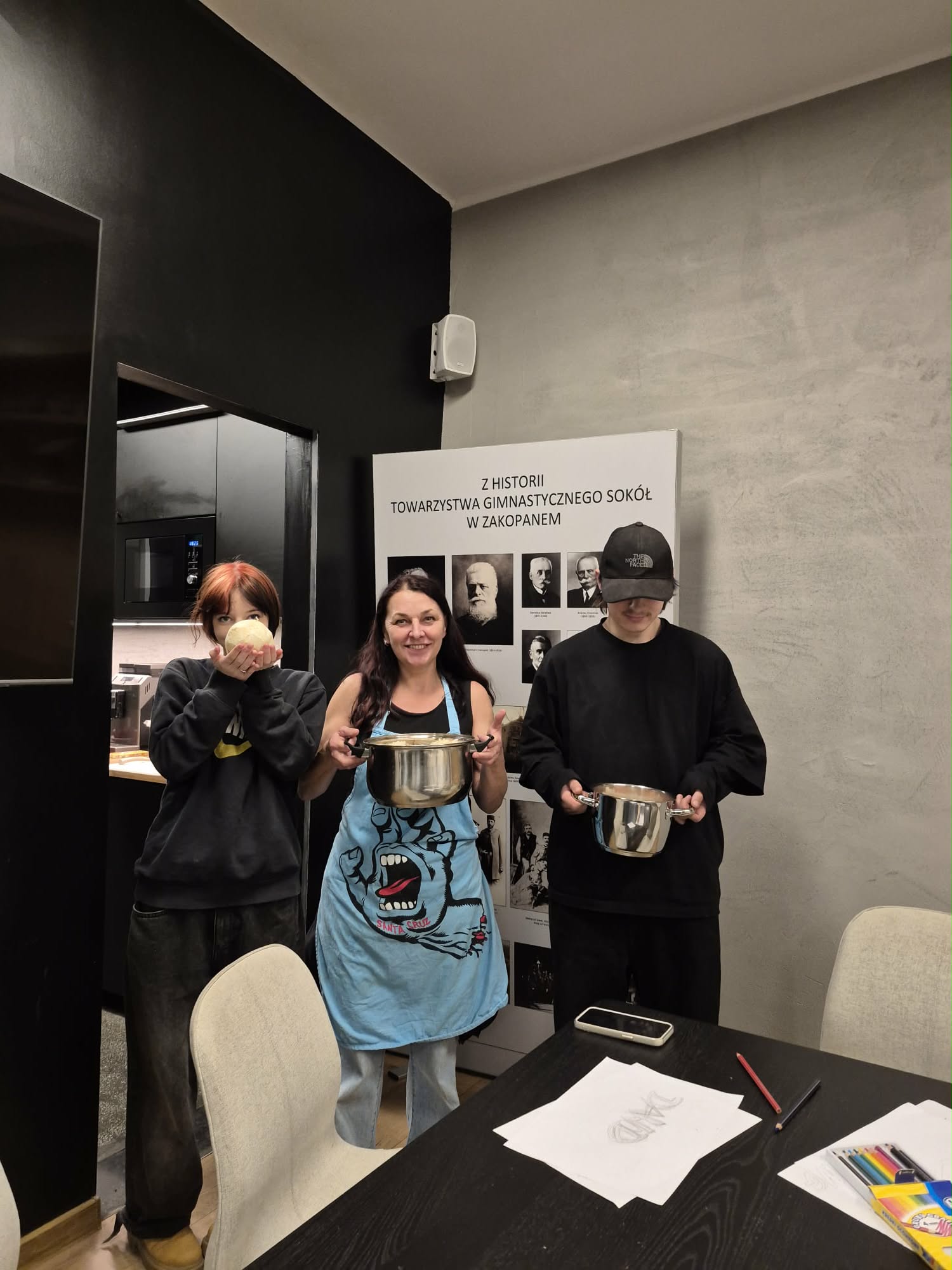 Trzy osoby trzymają garnki z jedzeniem.