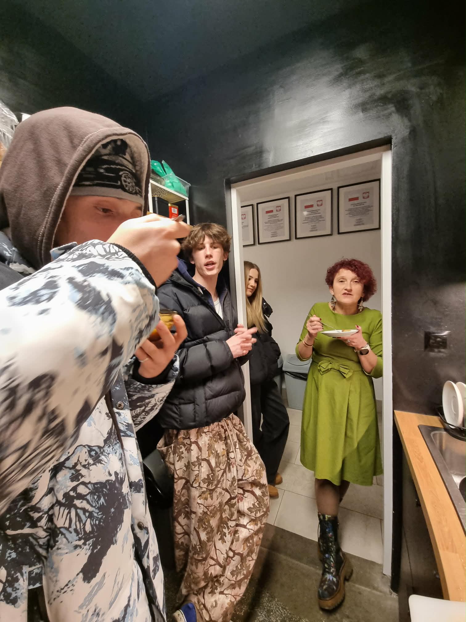 Kilka osób je wspólnie ugotowane potrawy.