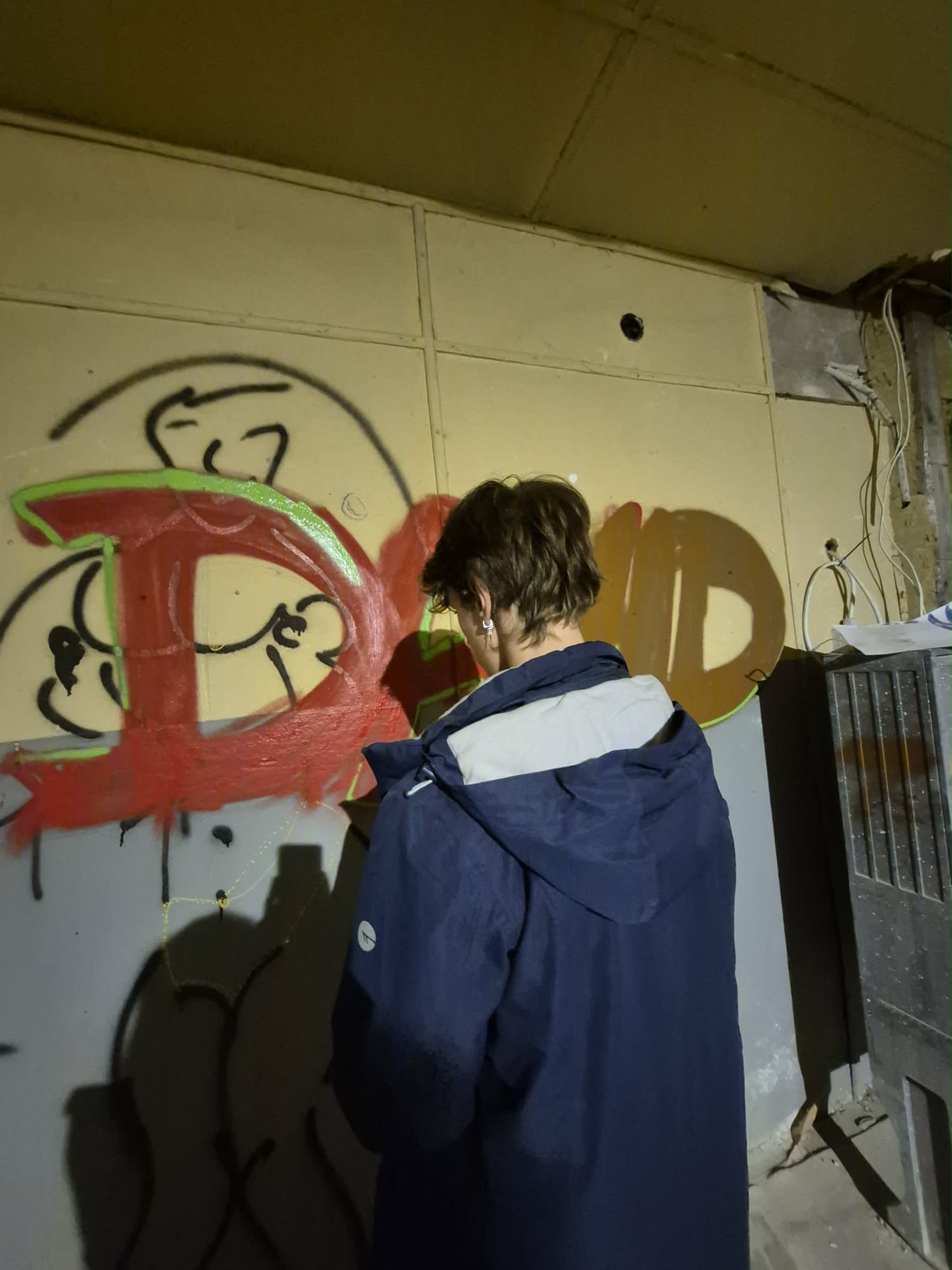 Chłopak robi czerwone graffiti.